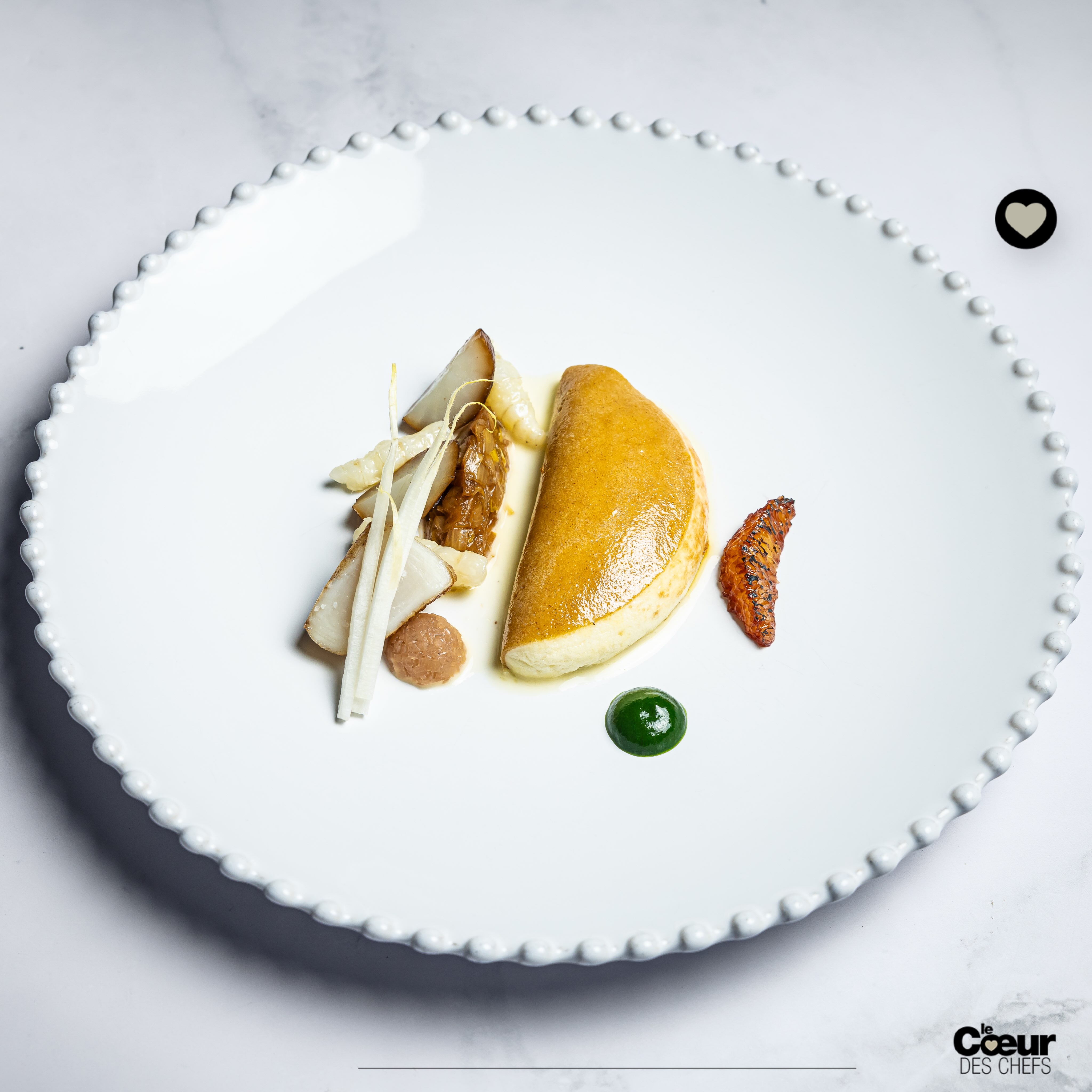 Une cuisine liée aux vins de Bourgogne à @maisonlameloise 
.
La cuisine de @ericpras_officiel est différente de celle de Jacques Lameloise, qui avait des assiettes précises avec peu d’éléments, des sauces exceptionnelles, et surtout une idée forte, “la cuisine doit s’adapter aux vins de Bourgogne” :
« C’est l’une des grandes leçons que j’ai retenues de lui”, explique Éric Pras. “Ici, il ne faut pas seulement cuisiner : il faut penser au vin en permanence. »
.
La cave oriente la ligne : « Je m’adapte aux vins. Par exemple, j’avais un sorbet citron arrosé de ratafia dans une dégustation, une sorte de trou normand bourguignon avant la viande. J’adorais l’idée. Mais sur certains menus, avec des grands amateurs de vin, cela pouvait casser la continuité de l’accord pour le verre suivant. Je l’ai pris en compte : aujourd’hui, je place plutôt un petit plat végétal avant la viande, qui prépare le palais à la suite et colle mieux au travail que nous faisons avec notre sommelier Sébastien Reymond sur les accords mets & vins.»
.
“La cuisine de cette maison doit s’adapter aux vins de Bourgogne.”
.
👉 À lire dans la revue @lecoeurdeschefs Numéro 19 : “Éric Pras, Lameloise à Chagny” : une cuisine liée aux vins de Bourgogne, l’amitié avec Jacques Lameloise et le parcours construit et réfléchi d’Éric Pras pour cibler avec soin les maisons où il allait apprendre. 
.
❤️ Entrez dans l’itinéraire “La Route du Coeur” ! Devenez ambassadeur/diffuseur de @lecoeurdeschefs en partageant la revue dans votre Maison (Lien en bio : « La Route du Coeur ».) Vous pouvez également vous abonner ou commander un numéro paru (Lien en bio : « La boutique »).
.
Plat : “Crêpe à la farine de gaudes soufflée de saint Jacques, beurre monté au crémant de Bourgogne et orange.” Photo © @ilyafoodstories 
.
#lecoeurdeschefs #ericpras #lameloise #vinsdebourgogne #bourgogne